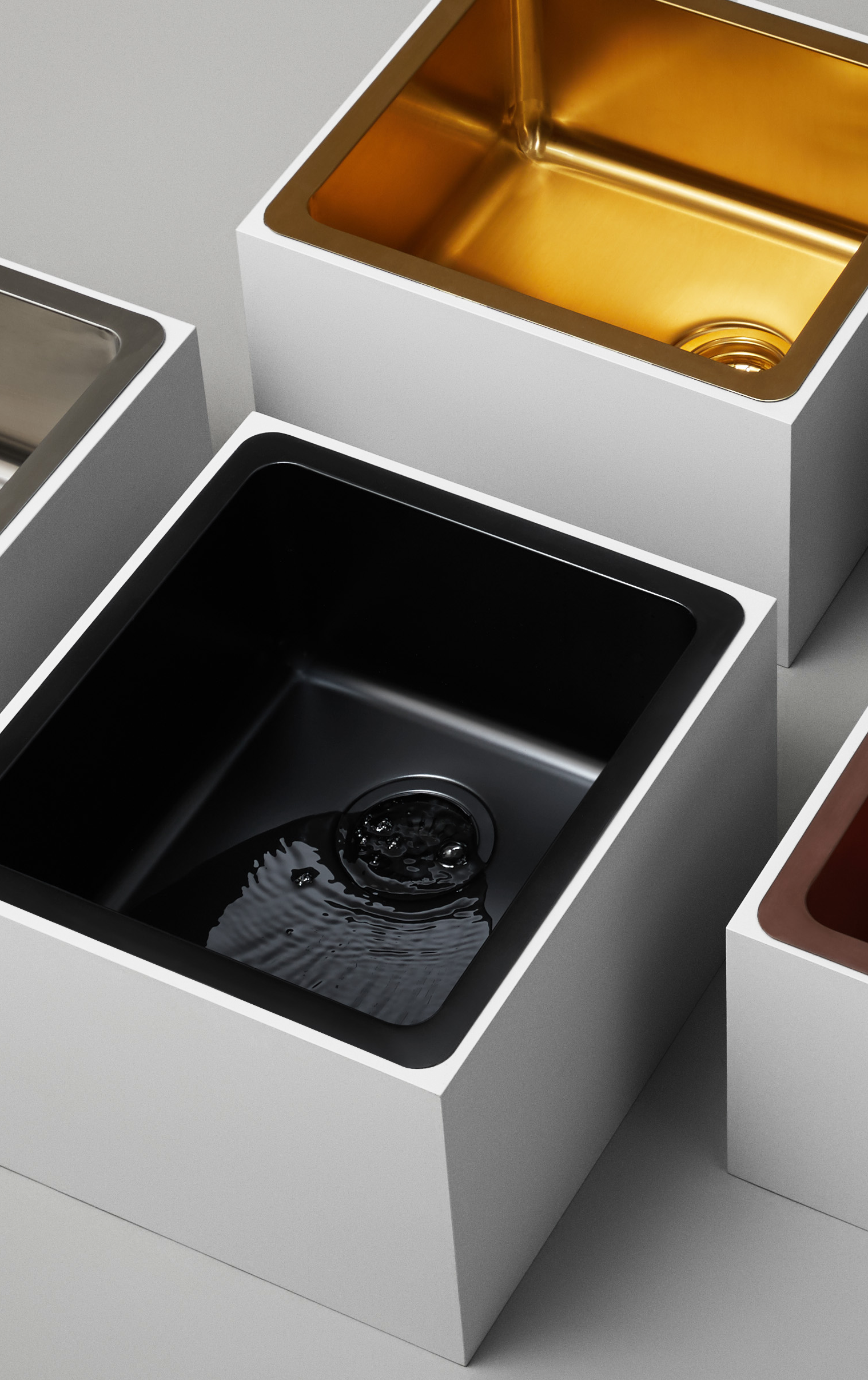 Still life photography showcasing Titan medium bowl sinks in brass and matte black, highlighting the contrast and elegance of brass and black kitchen sinks with slight overlay filter.