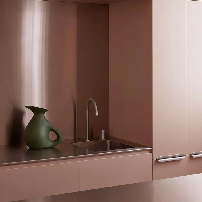 Close up image of benchtop at Hazel House featured project by Nat Turnbull. Muted salmon colour cabinets with Titan stainless steel kitchen sink and Titan stainless steel kitchen tap.